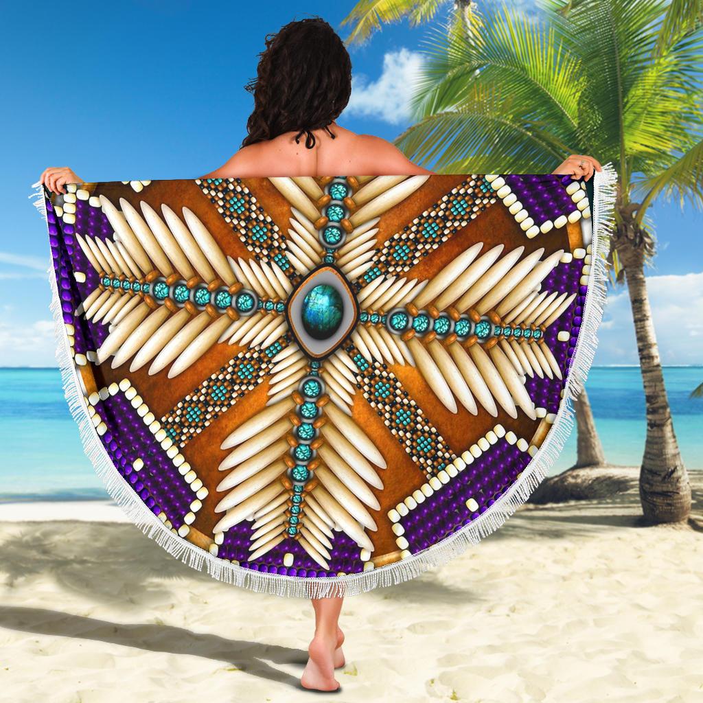 Folded round beach blanket held up, purple mandala with turquoise details and white fringe