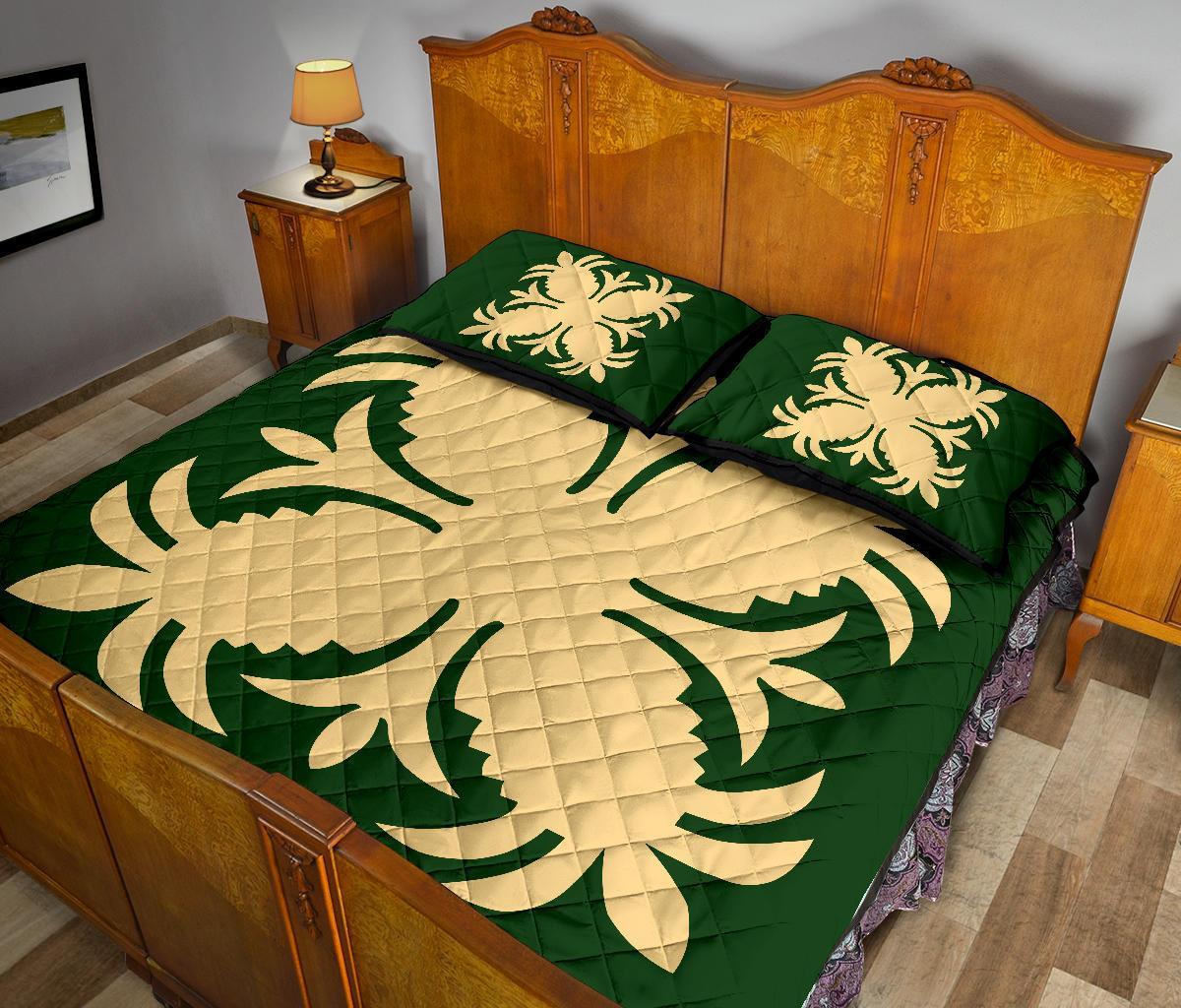 Green Hawaiian quilt bed set with cream hibiscus-style print and two matching pillowcases