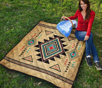 Colorful southwest geometric quilt laid flat, featuring a large central diamond and tan background.