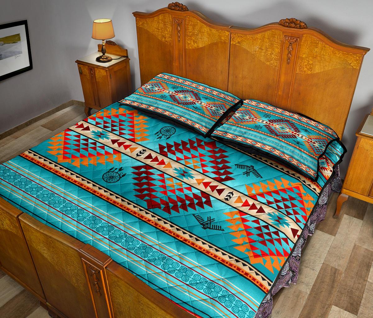 Quilt bed set on bed with bold geometric pattern and dreamcatcher icons, two pillows