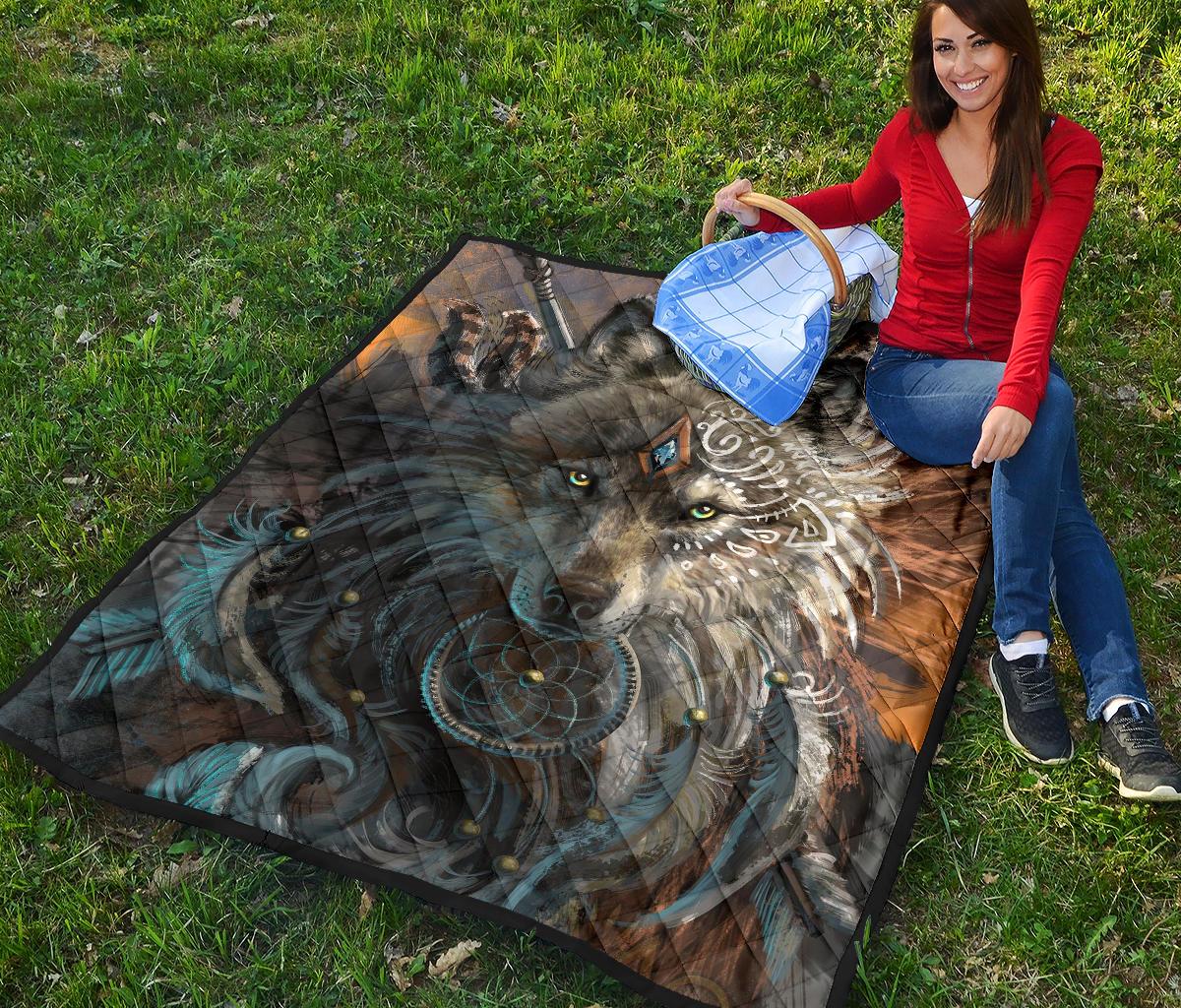 Large multicolor wolf quilt laid on grass with turquoise and brown tribal-style details