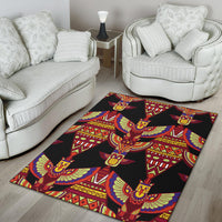 Black area rug with repeating winged tribal ornaments in red, yellow, blue and green