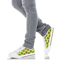 Low-top sneakers on jeans, white sole, green/yellow Ankara print, white laces
