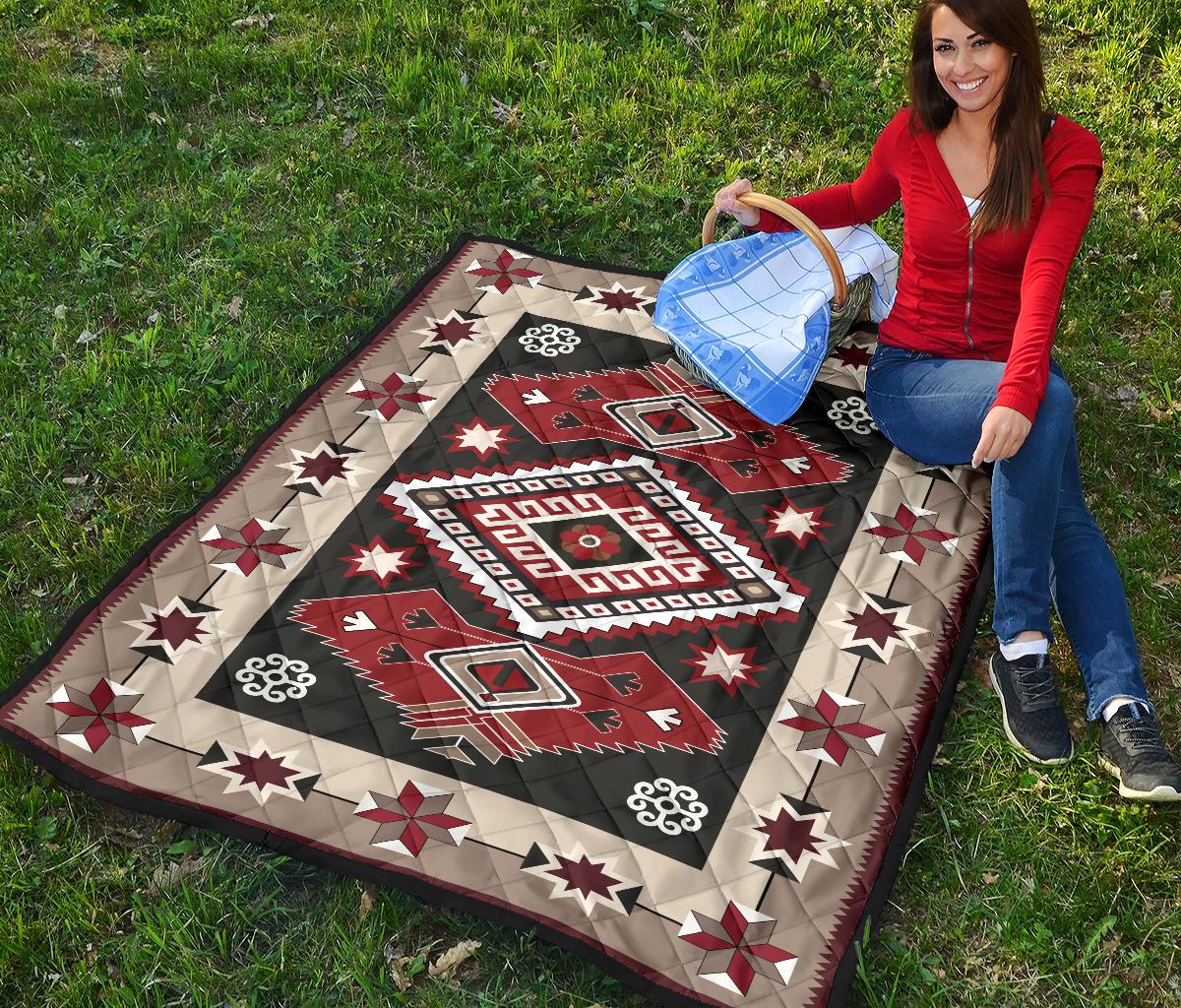 Quilt laid on grass with red and dark gray center diamond and star blocks border.