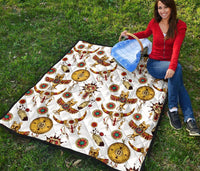 Multicolor Native American totems quilt laid flat on grass with detailed bull and feather motifs