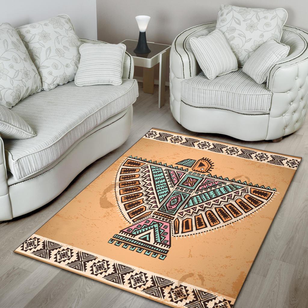 Beige area rug featuring colorful tribal bird design with black geometric border and fringe-free edge