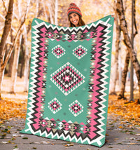 Turquoise geometric blanket with pink and black diamond motifs and chevron border