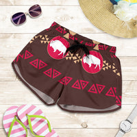 Brown swim shorts flat lay with pink bison circles, geometric trim, black drawstring waistband