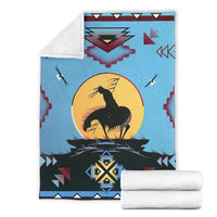 Light blue blanket with white backing fold; black horse on yellow sun and red triangles