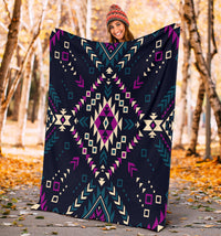 Large dark tribal pattern blanket held outdoors; navy base with purple and teal motifs