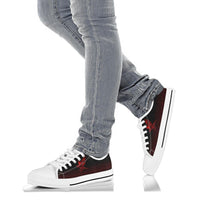 White low-top sneakers with red rune graphic worn with light blue jeans