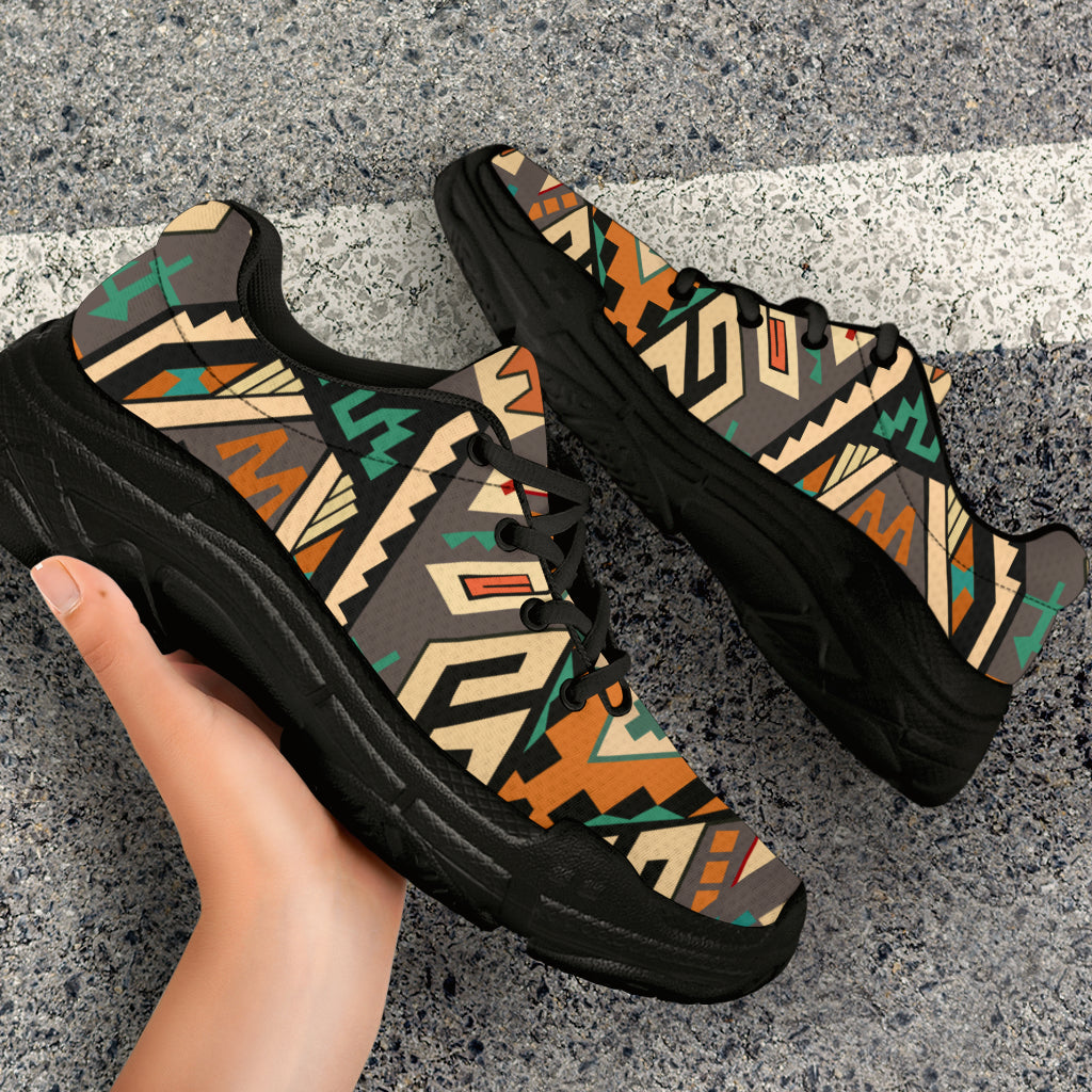 Close-up of chunky lace-up sneakers with Native tribal geometric upper and black chunky sole
