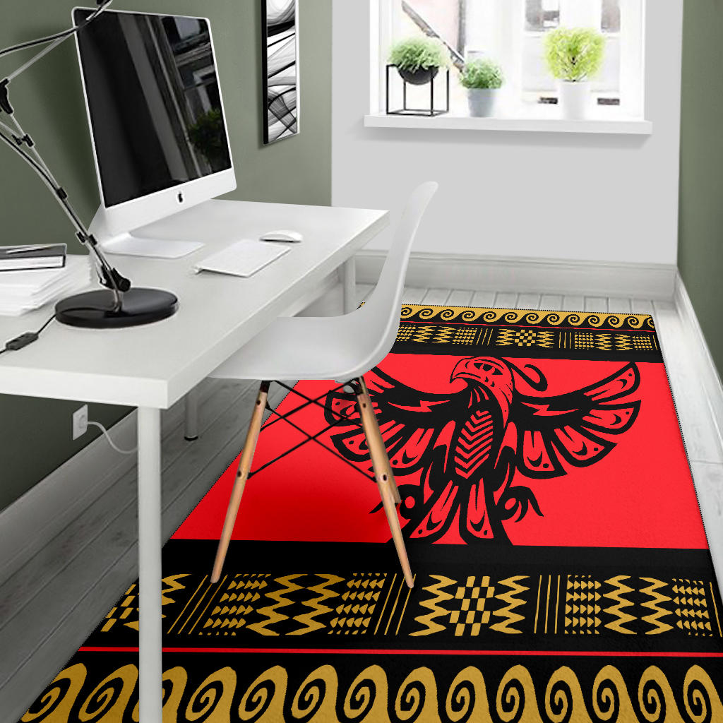 Red area rug showing black bird emblem with yellow zigzag and swirl border strips