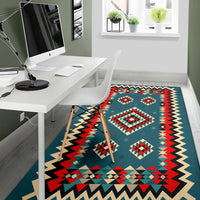 Teal geometric area rug with red diamond motifs and wide zigzag border
