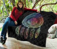 Black quilt stretched on outdoor chair, featuring multicolor mandala dreamcatcher and feathers