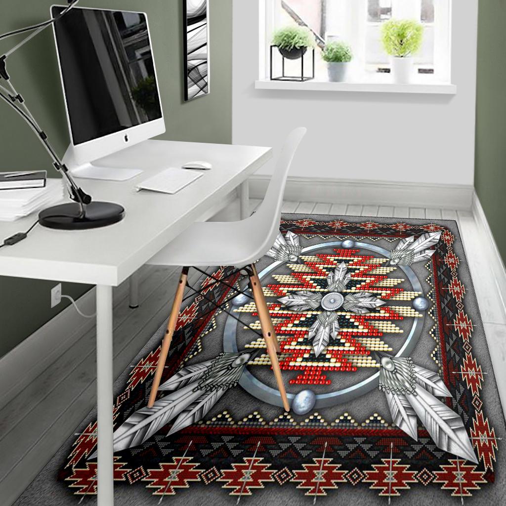 Native American style area rug with dark gray base, central wheel medallion, and red zigzag edge