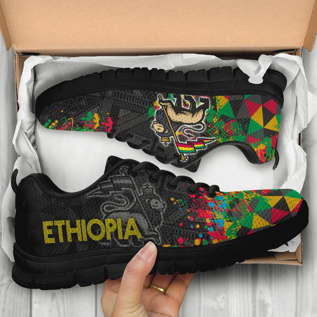 Black Ethiopia sneakers in box, colorful geometric side panels and large yellow ETHIOPIA logo