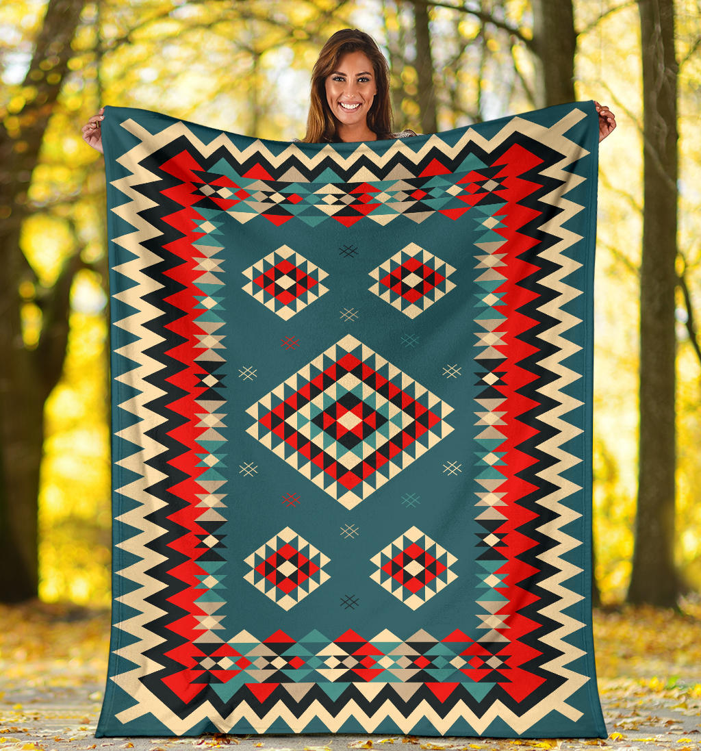 Multicolor geometric throw blanket with diamond motifs and zigzag border held outdoors