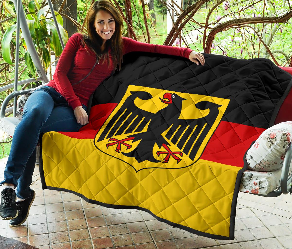 Germany flag quilt draped outdoors with black quilted edge, red/yellow stripes, eagle emblem