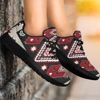 Tribal sport sneakers on feet, red-brown and white star pattern with black laces