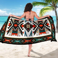 Colorful tribal sarong laid flat, black with large geometric red, green, and white motifs