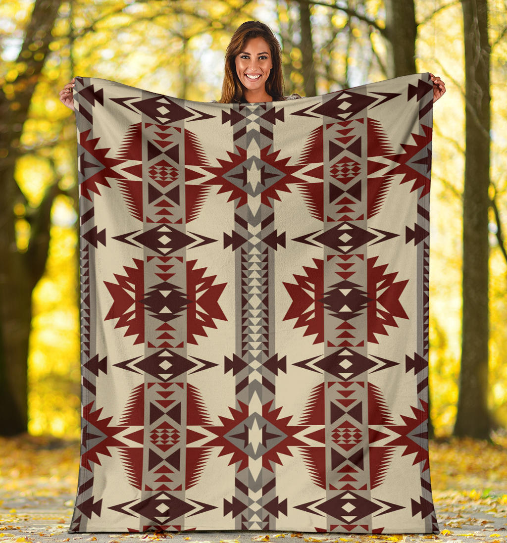 Cream blanket with repeating red and gray geometric stars and columns pattern