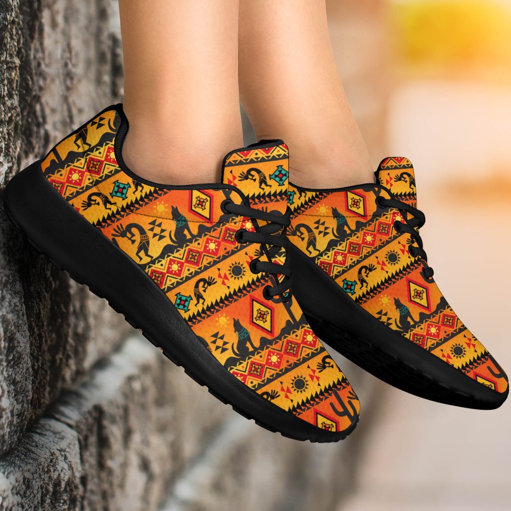 Native motif sport sneakers on feet, multicolor uppers with black sole and laces