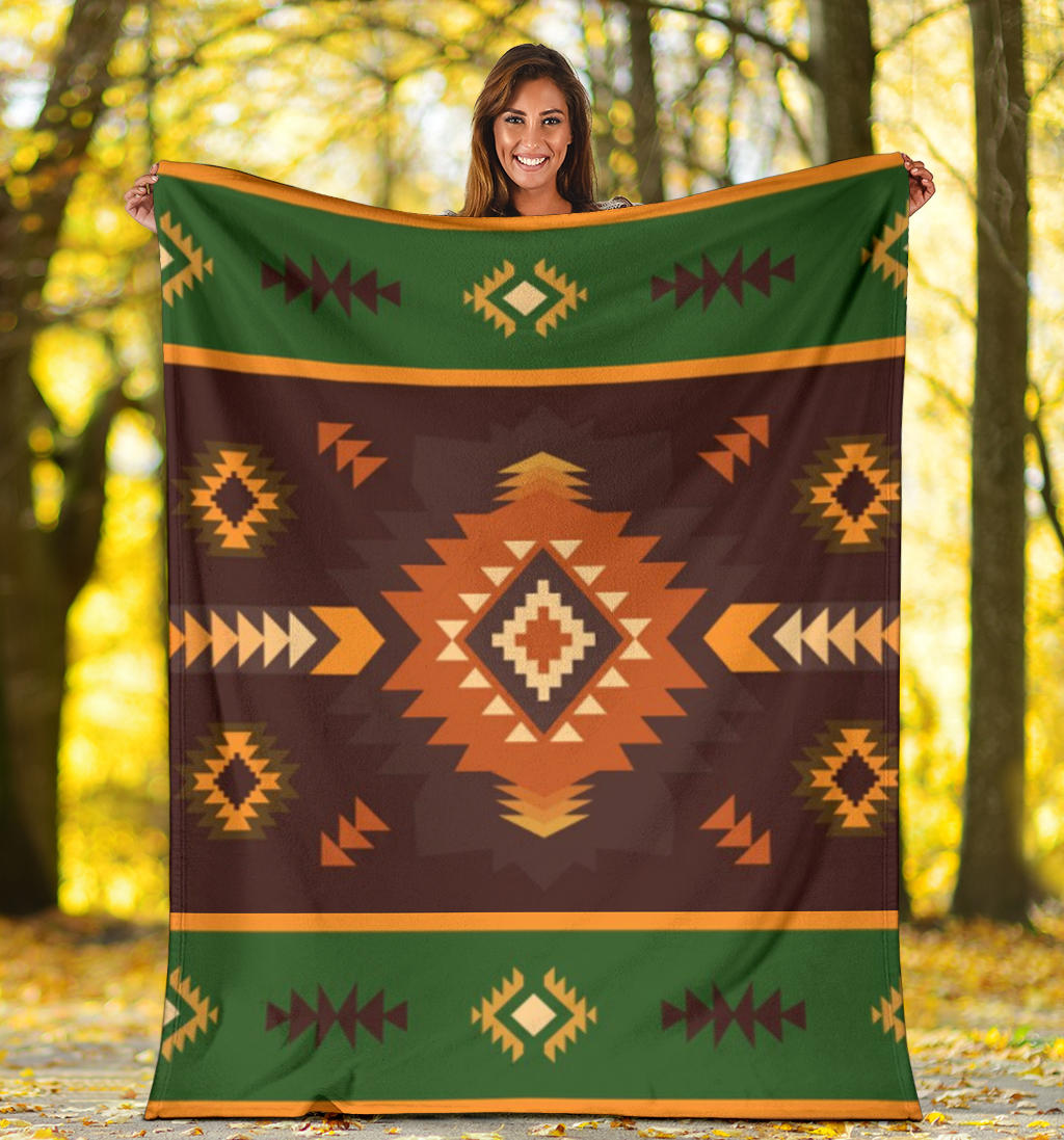 Geometric blanket outdoors showing dark brown field with green top stripe and orange diamond motif