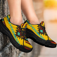 Yellow geometric print chunky sneakers on feet, black laces and black platform sole