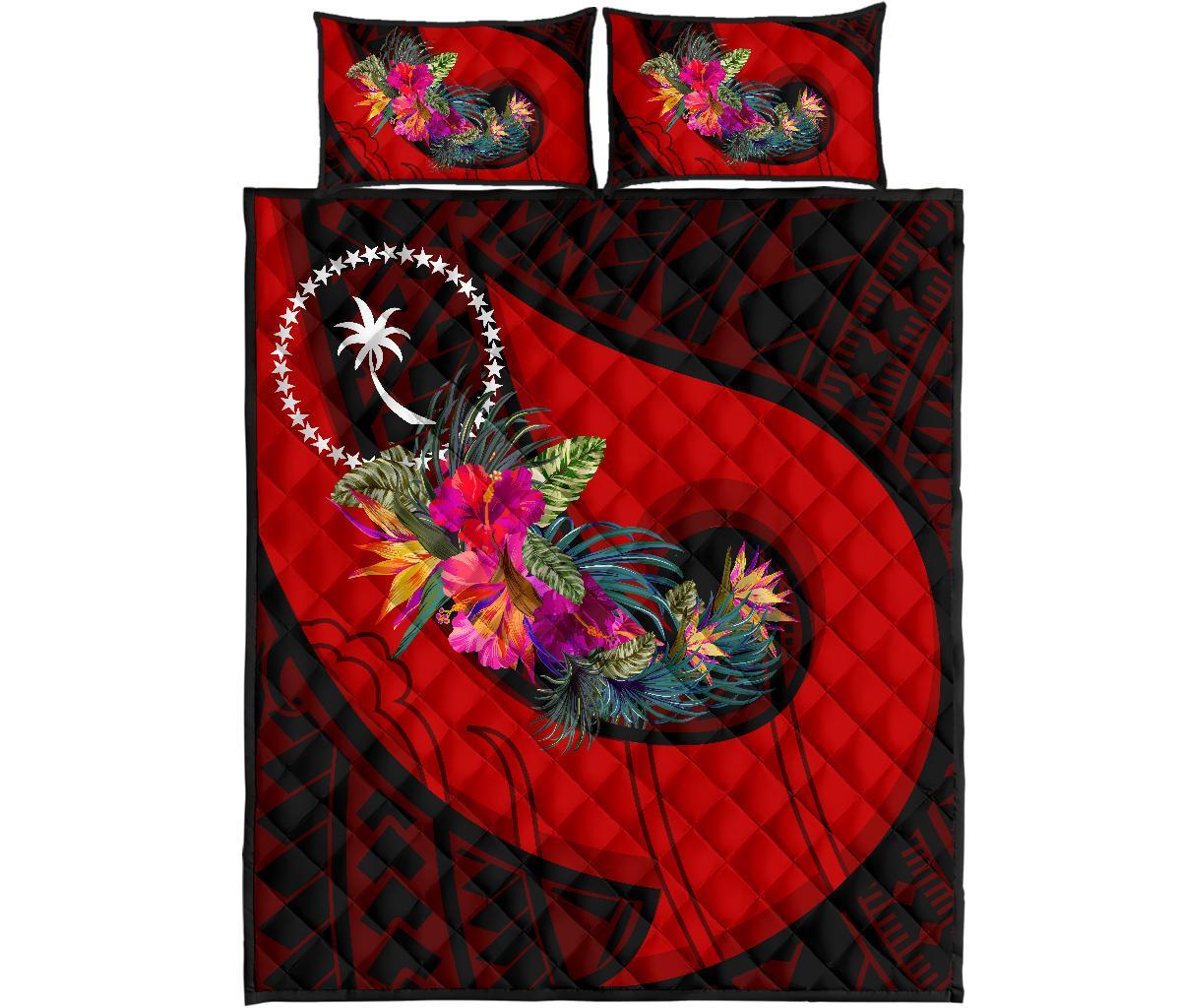 Red quilt set with Polynesian hook-and-hibiscus floral pattern on quilt and 2 matching pillows