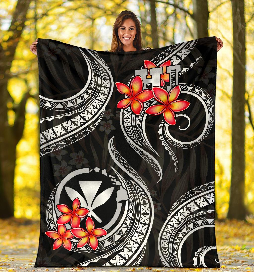 Black Polynesian blanket laid flat with red plumeria and white circular crest patterns