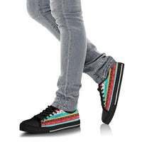 Low-top canvas sneakers worn with light blue jeans; multicolor ethnic stripe on black