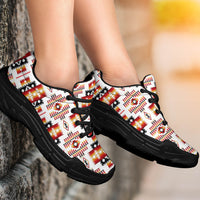 Tribes pattern chunky sneakers on feet, white upper with red/orange/black pattern, black lace-up