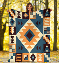 Navy arrow pattern blanket held up outdoors, multicolor geometric border and center diamond