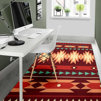 Red geometric area rug with zigzag rows, diamond border, and green triangle accents