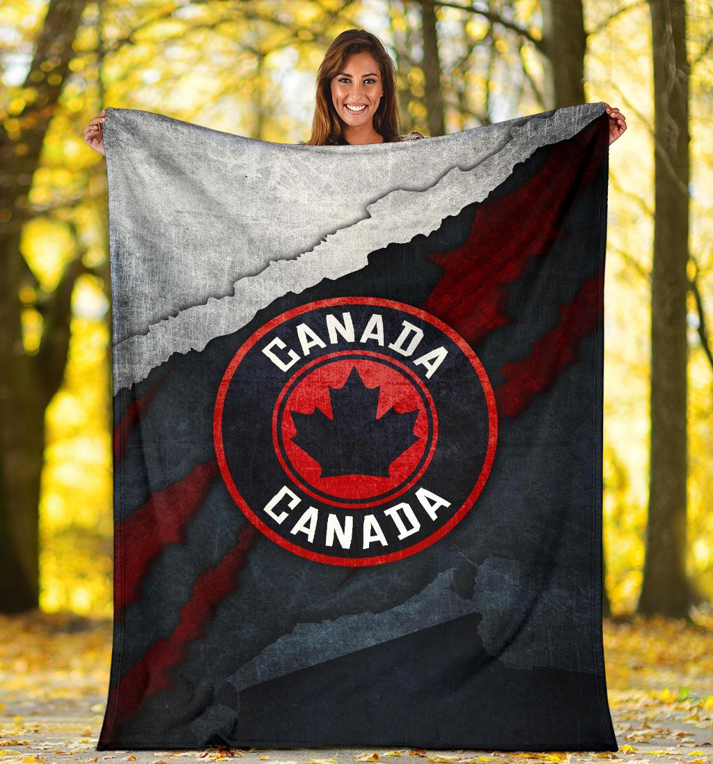 Folded Canada blanket, grunge flag map and red maple-leaf emblem on black