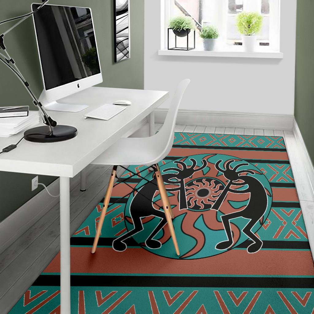 Teal and rust Kokopelli rug under desk, with black bird-like figure and geometric border
