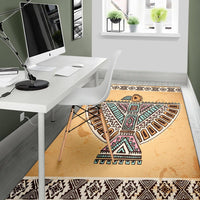 Beige Native-style geometric area rug with multicolor bird symbol and black patterned edge