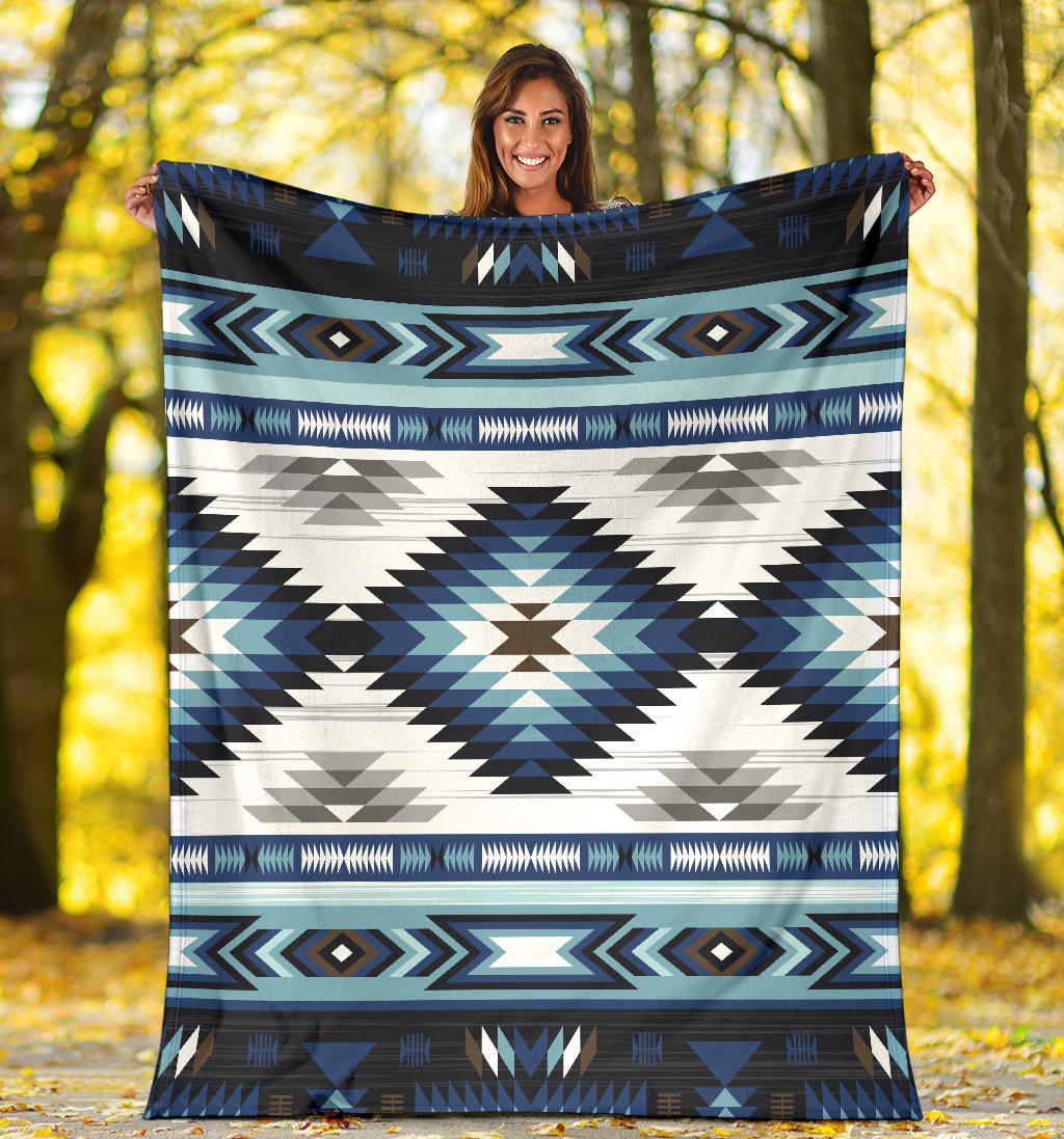Blue and white tribal blanket with bold zigzag stripes and diamond medallion
