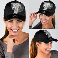 Black cap worn by woman with white raven graphic and circular emblem