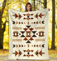 Cream geometric blanket with centered diamond and arrow patterns in black, rust, and tan