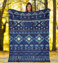 Navy blue patterned blanket displayed outdoors, bold diamond and stripe design