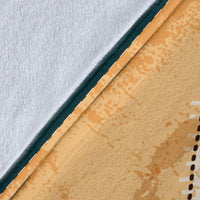 Close-up of brown blanket corner with white reverse side and dark teal trim