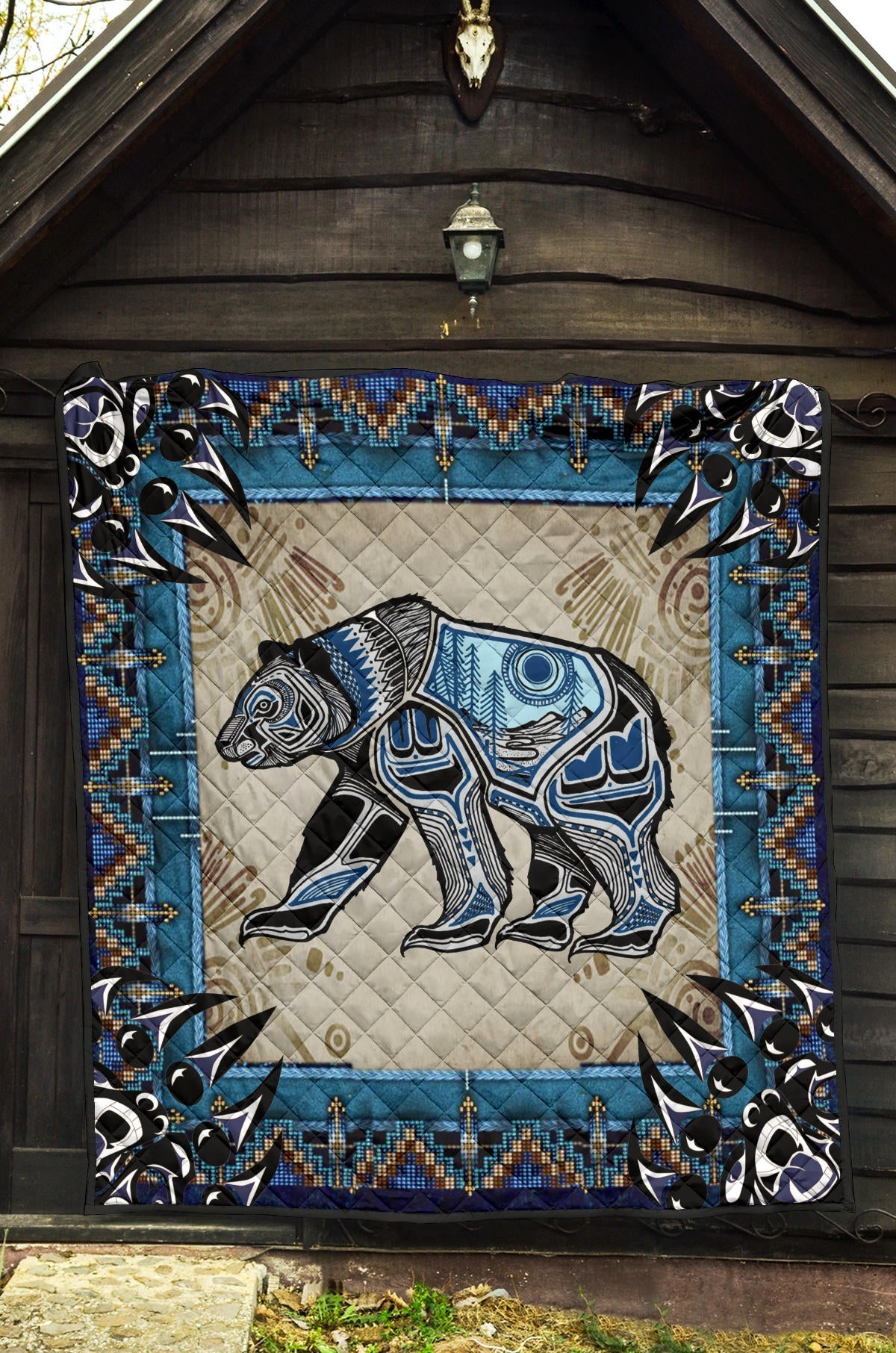 Quilt with large bear illustration, blue accents, black corners, and zigzag bead pattern trim