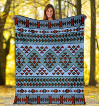 Blue patterned blanket displayed outdoors, large diamond motifs and striped border design