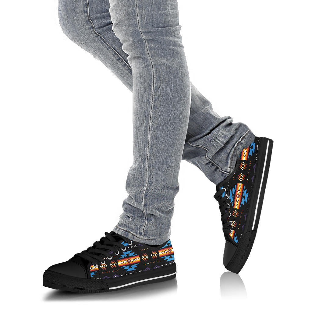 Black low-top sneakers on jeans, blue Native pattern, lace-up, black sole