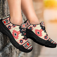 Chunky sneakers on feet: cream upper with pink and navy geometric pattern, black laces, black sole