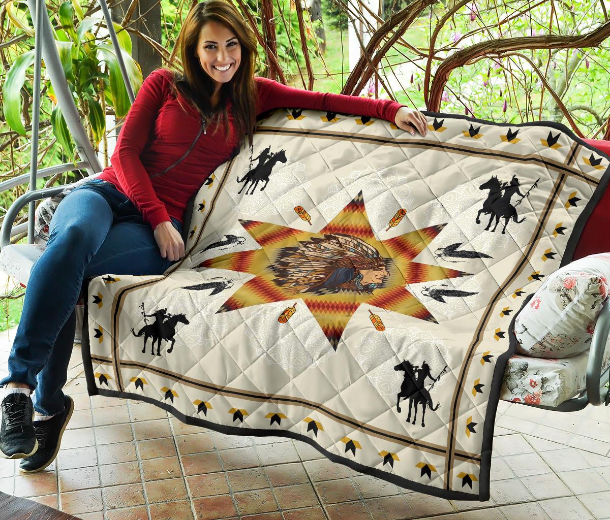 Chief and warriors quilt draped on patio chair; white background with starburst, horses and birds