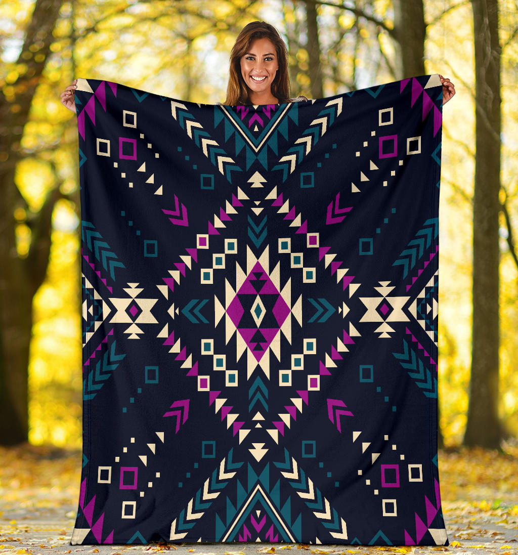 Dark color tribal geometric blanket held up; multicolor navy, teal, purple, cream