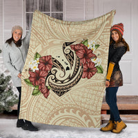 Beige Polynesian blanket displayed indoors, fish hook motif with hibiscus and plumeria print